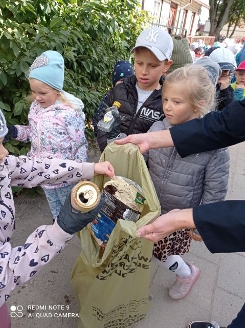 dzieci zbierają śmieci nad rzeką.